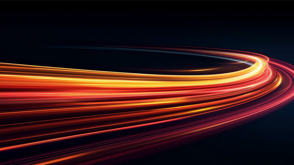 Curving light trails in shades of orange and red against a dark background, symbolizing speed, movement, and data flow.